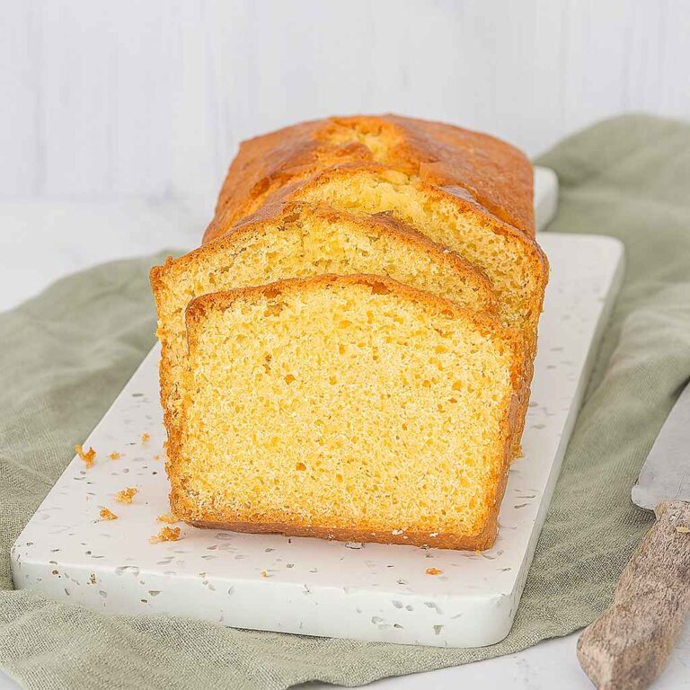 Classic loaf cake sliced on a board, showing moist crumb.