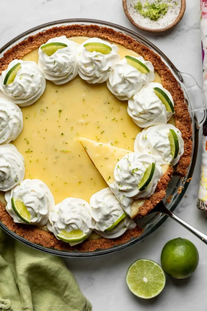 Slice of 7-ingredient key lime pie with a graham cracker crust and lime garnish.