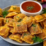 Plate of golden Fried Ravioli served with marinara sauce
