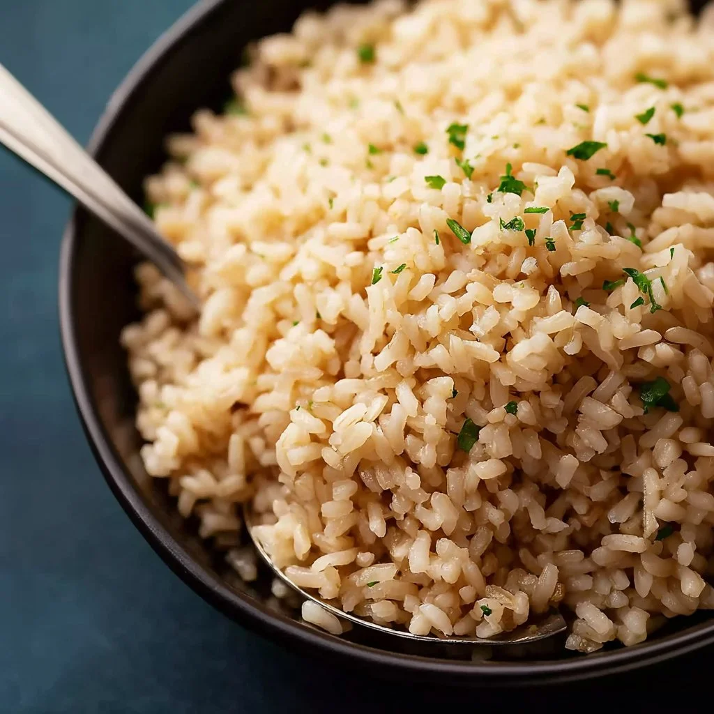 Bowl of cooked brown rice with fresh vegetables and herbs