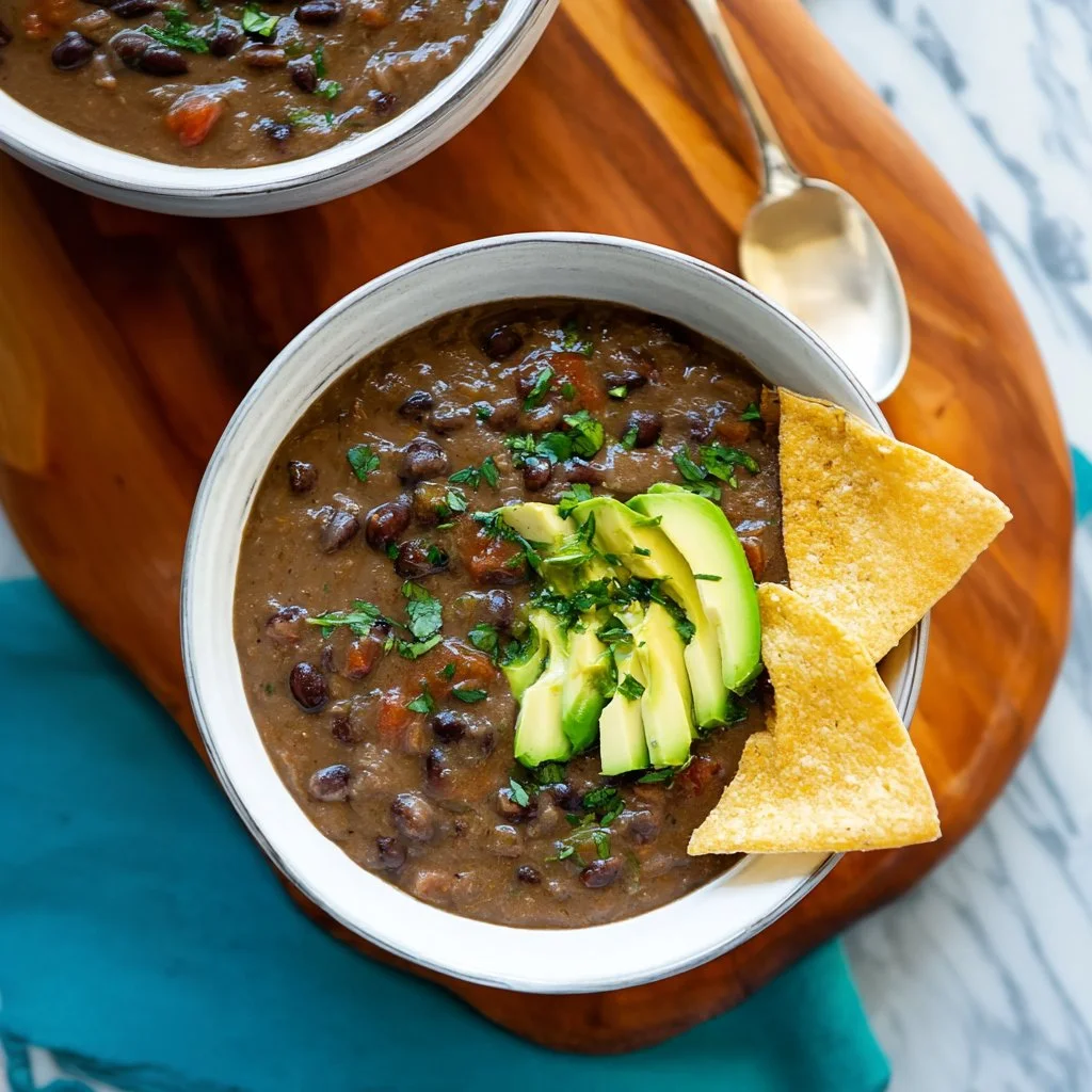 Deliciously spicy black bean soup in a rustic bowl garnished with herbs