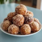 Freshly made banana donut holes topped with powdered sugar