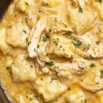 Crock Pot chicken and dumplings served in a bowl with herbs and spices