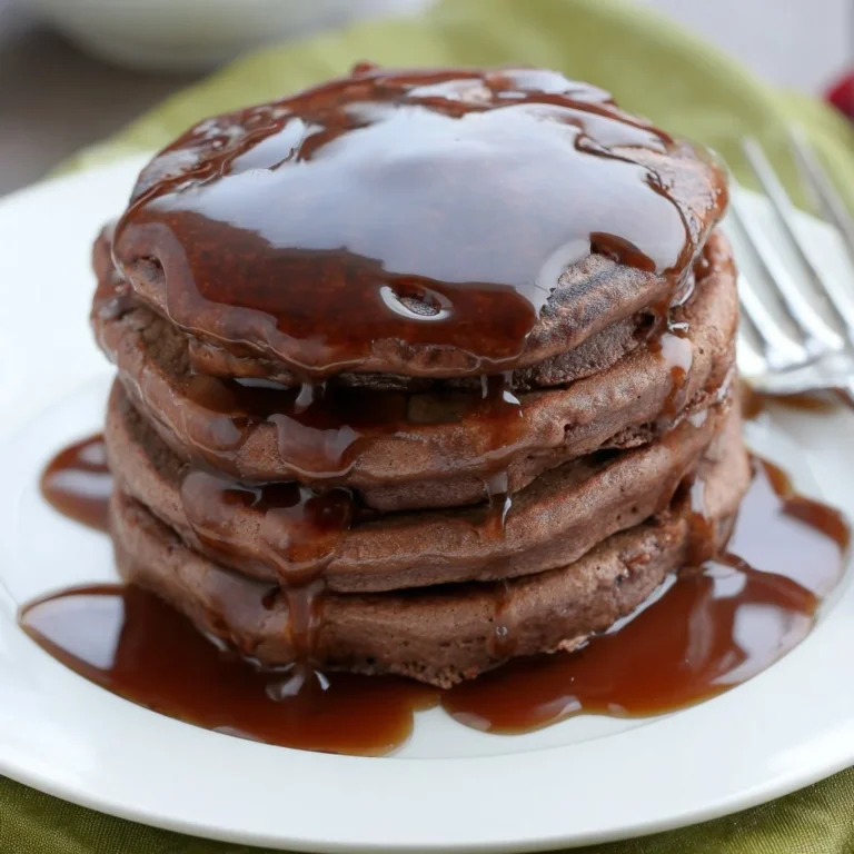Delicious double chocolate pancakes topped with chocolate syrup and berries