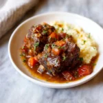 Delicious braised short ribs served with vegetables and garnishes