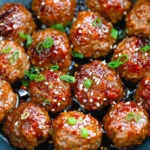 Plate of homemade Mongolian meatballs garnished with herbs and sauce