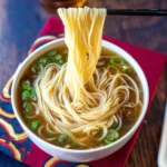 Bowl of quick and easy Oriental noodle soup with fresh vegetables and herbs