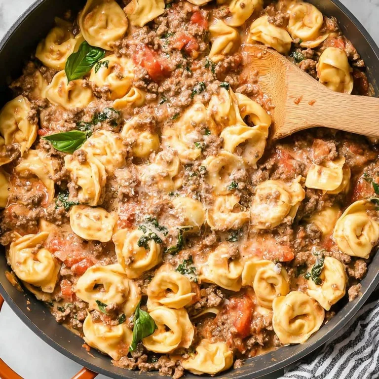Plate of comforting ground beef tortellini with sauce and garnish