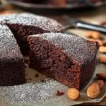 Delicious chocolate almond yogurt cake topped with chocolate ganache and almonds