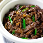 Delicious slow cooker Mongolian Beef served with rice and vegetables.