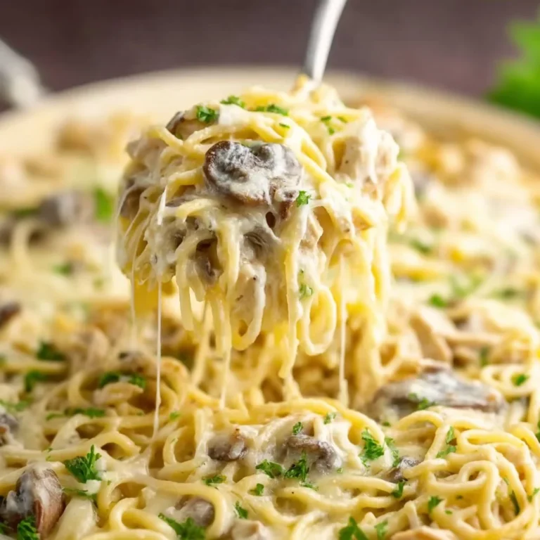 A comforting bowl of chicken tetrazzini topped with cheese and herbs.