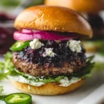 Blueberry feta burgers topped with jalapeño aioli on a rustic wooden table.