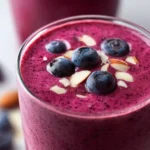 Delicious blueberry smoothie in a glass with fresh blueberries and mint leaves
