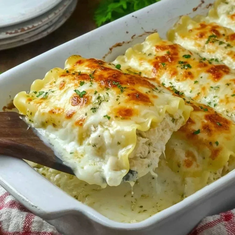Delicious Chicken Alfredo Lasagna Roll Ups served on a plate with fresh herbs.