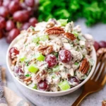 Delicious chicken salad with grapes, pecans, and celery served in a bowl.