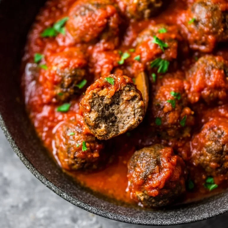 Delicious homemade baked meatballs served with pasta and marinara sauce.