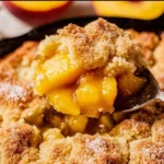 Delicious homemade peach cobbler served warm with ice cream.