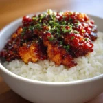 Plate of Honey BBQ Chicken served with rice, garnished with green onions.