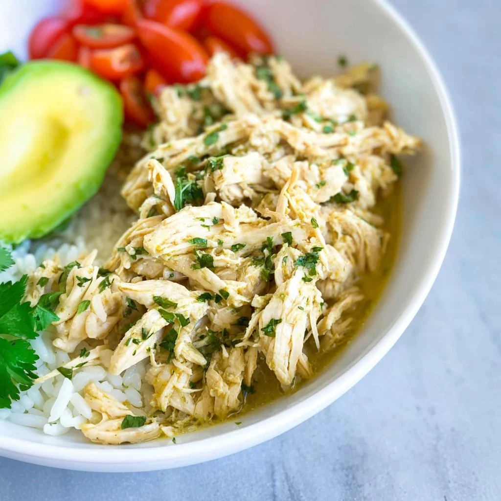 Instant Pot shredded chicken served in a bowl with herbs and spices.