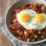 Delicious corned beef hash served in a bowl, garnished with herbs.