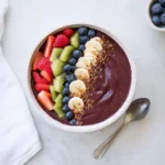 A colorful acai bowl topped with fresh fruits and granola, perfect for breakfast.