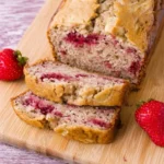 Freshly baked strawberry banana bread served on a wooden board.