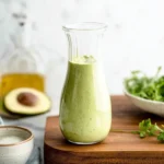 5-Ingredient creamy avocado dressing in a bowl with fresh ingredients