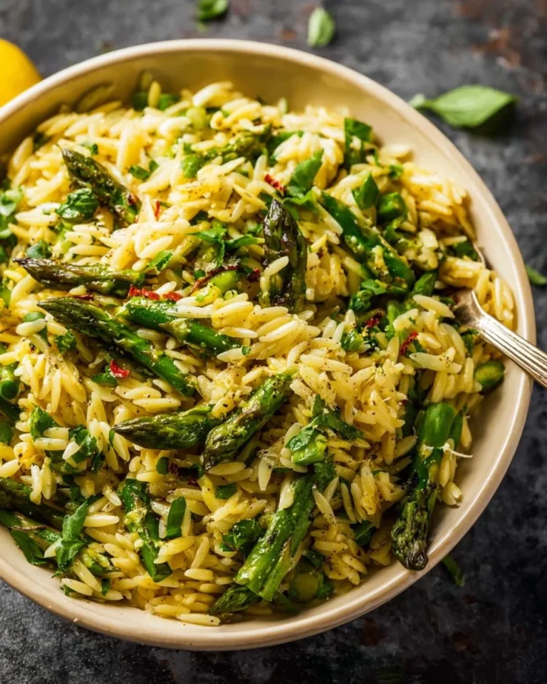 Delicious asparagus orzo dish garnished with fresh herbs