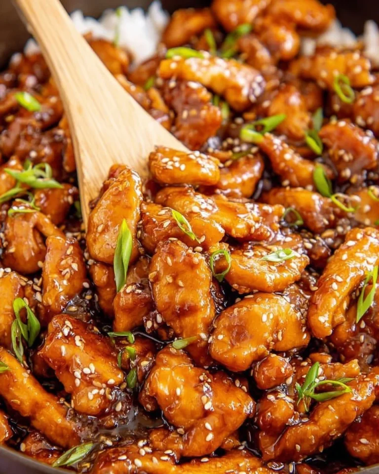 Plate of Bourbon Chicken garnished with green onions and served with rice
