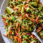 Delicious Brussels sprout coleslaw displayed in a bowl with fresh ingredients.