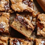 Chewy brown butter blondies with melted chocolate chips on a baking tray.