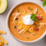 Bowl of flavorful Chicken Enchilada Soup topped with cheese and cilantro