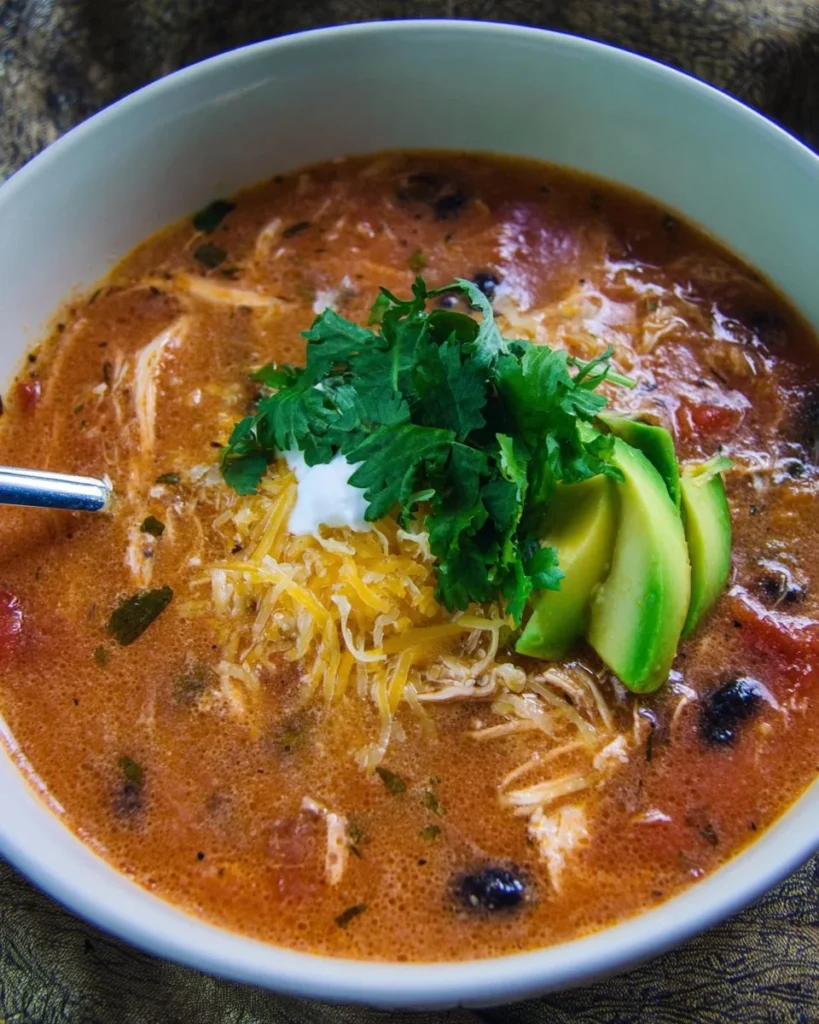 Bowls of delicious Chicken Enchilada Soup topped with cheese and cilantro