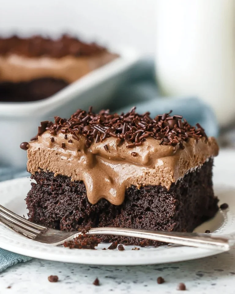 Delicious Chocolate Poke Cake topped with creamy frosting and drizzled chocolate sauce