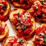 Delicious garlic bread bruschetta topped with fresh tomatoes and basil
