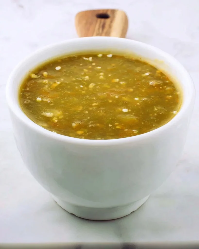 Bowl of homemade green enchilada sauce with fresh herbs and spices