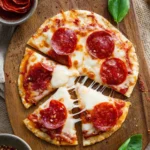 Homemade pita pizza topped with fresh vegetables and cheese.