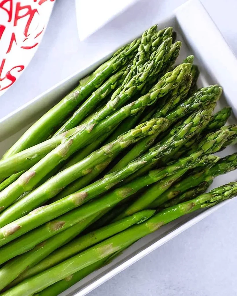 Quick microwave asparagus dish served on a plate with seasoning