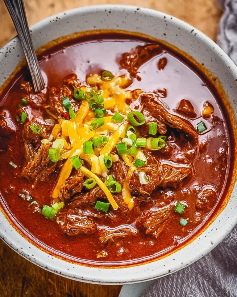 A bowl of hearty Texas Chili with beans and spices, garnished with jalapeños.