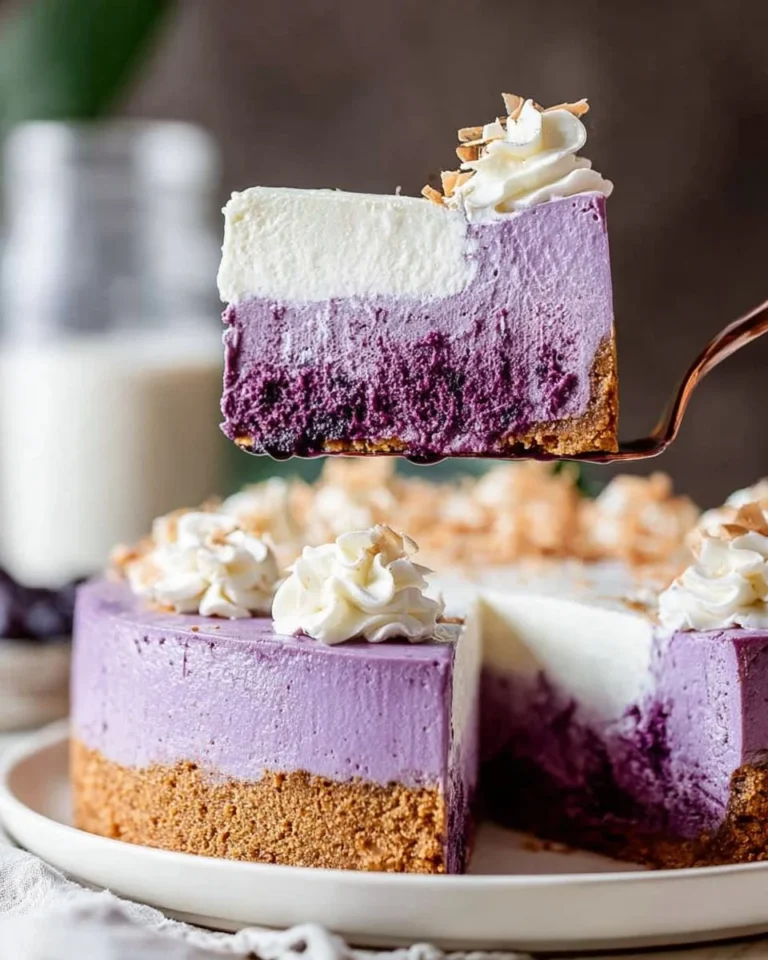 Creamy ube cheesecake topped with purple yam and garnished with fresh fruit