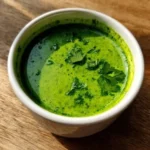 Zesty cilantro garlic sauce in a small bowl with fresh herbs