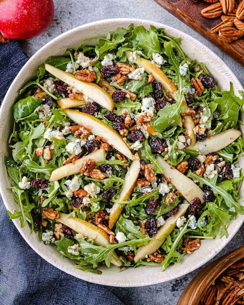 Freshly prepared Arugula Pear Salad with fruits and nuts