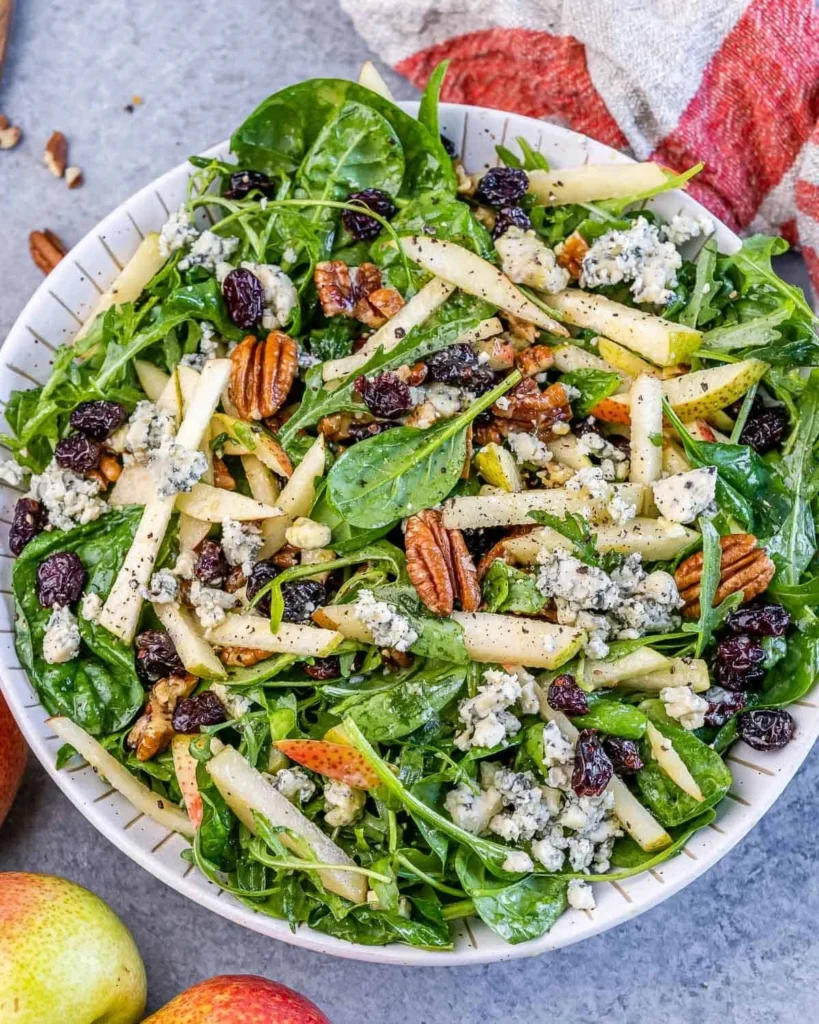 Freshly prepared Arugula Pear Salad with fruits and nuts