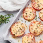 Delicious baked tomatoes fresh out of the oven, garnished with herbs.