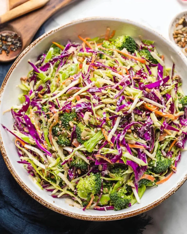 Colorful bowl of fresh broccoli slaw with carrots and dressing