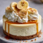 Creamy banana cheesecake topped with fresh banana slices and whipped cream