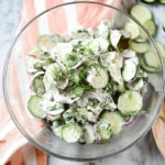 Creamy cucumber yogurt salad with fresh herbs and spices in a bowl
