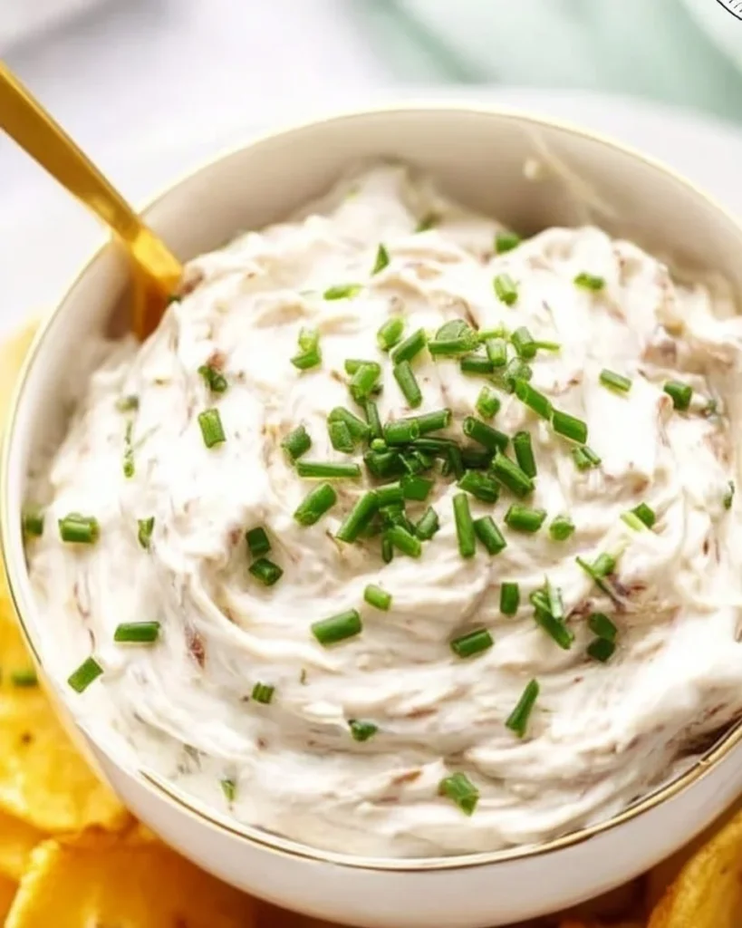 Bowl of homemade French onion dip with crackers and vegetables