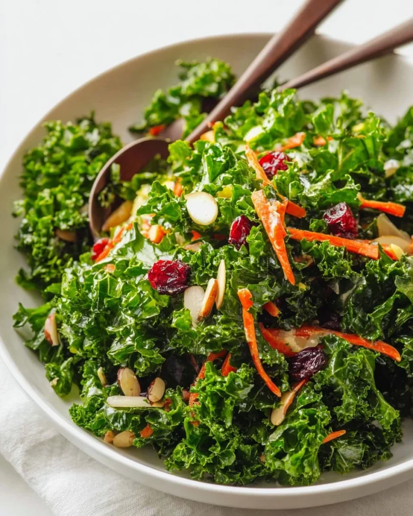 Kale salad with lemon vinaigrette dressing and fresh ingredients on a plate.