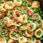 Delicious bowl of Pea Pancetta Pasta topped with fresh peas and crispy pancetta